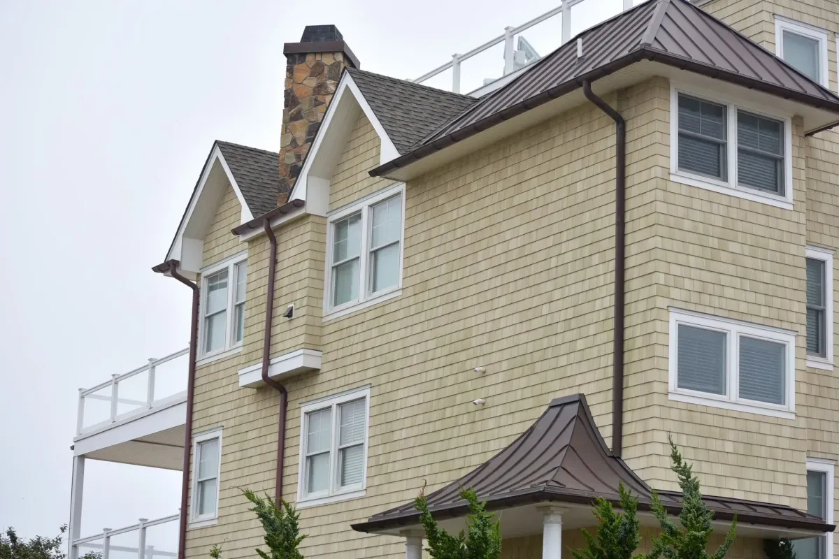Bronze seamless gutter and downspout on a cedar-shingle home with metal roof in Haddonfield, NJ