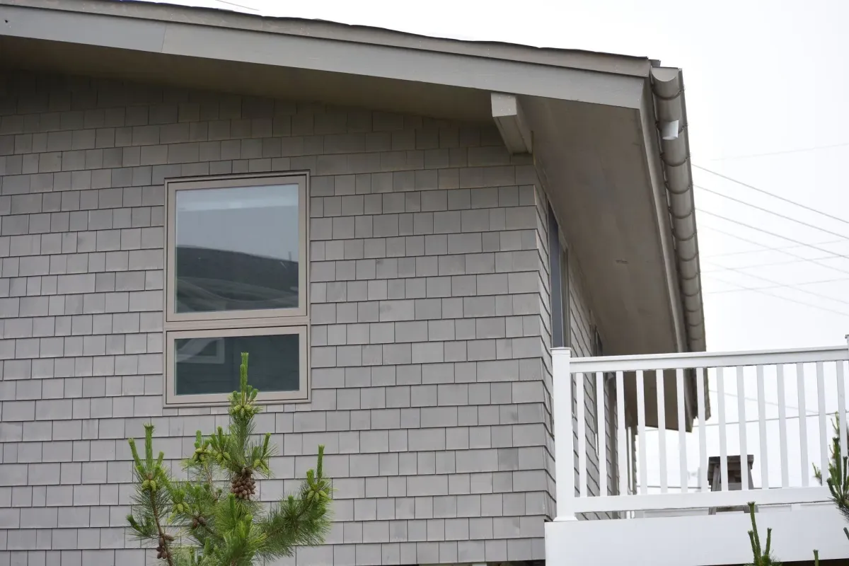 Gray seamless gutter along the gable roofline of a shingle-sided home in Glassboro, NJ