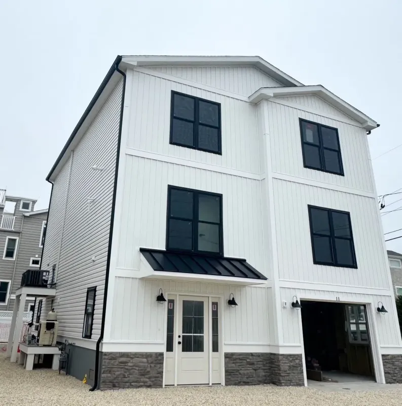 White seamless gutters and black downspout on a modern coastal home in Haddonfield, NJ