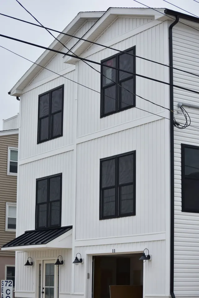 Black downspout and white seamless gutters on a tall three-story home in Haddonfield, NJ
